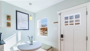 A bright hallway with a white bench, a framed map, and a window with a view of the street. - 
Hot Tub • Walk Downtown • Sleeps 11 • Near Royal Gorge (Cañon City)