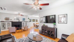 A modern living room with a fireplace, a dining area, and a kitchen. - 
Hot Tub • Walk Downtown • Sleeps 11 • Near Royal Gorge (Cañon City)