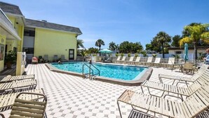 A pool area with lounge chairs and a pool.
