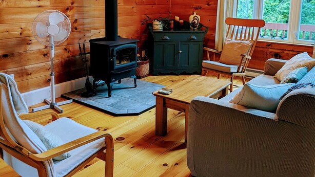 A cozy cabin interior with a wooden interior, a fireplace, a dining table, and seating arrangements. - Private Escape For 2 (Wakefield)