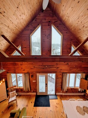 A wooden cabin with a high ceiling, large windows, a cozy seating area, and a view of a snowy deck outside. - Private Escape For 2 (Wakefield)