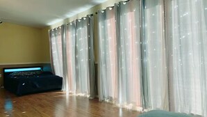 Habitació amb llit, capçalera amb il·luminació i cortines translúcides amb dibuix de estrelles.