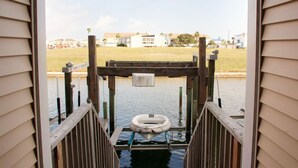 A wooden dock leading to a body of water with a floating life preserver. - Compass Bayfront Condo, Close to Beach & Pool! (Corpus Christi)