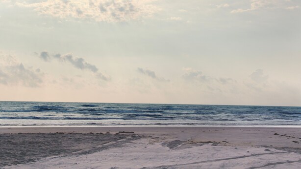 A beach with a sandy shore and the ocean. - Compass Bayfront Condo, Close to Beach & Pool! (Corpus Christi)