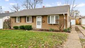 A single-story house with a front door, two windows, and a small front yard with grass and a few trees. - Sailor`s Escape with 3 bedrooms Near Naval Base! (Waukegan)