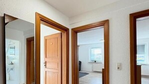 Ein Flur mit Holztüren, die zu einem Badezimmer und einem Schlafzimmer führen.