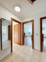 Un pasillo con puertas de madera que dan a un baño y un dormitorio.