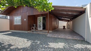 A covered outdoor area with a wooden building, a gravel path, and a door leading inside. - House w/ Barbecue 600 m From the Beach Nus0636 (Picarras)