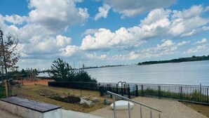 A waterfront park with a concrete bench, a metal railing, and a staircase leading to a viewing platform. - townhouse 20 (London)