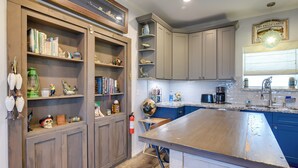 A kitchen with wooden cabinets, a large island, and various kitchen appliances. - Group-Friendly Hot Tub Haven in Galveston! (Galveston)