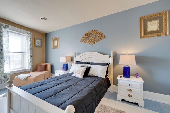 A bedroom with a bed, nightstands, a window with curtains, and wall decorations. - Walkable Racine Retreat! 1 Mi to Lake Michigan (Racine)