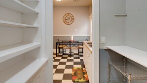 A kitchen with a checkered floor, a clock on the wall, and a welcome mat. - Walkable Racine Retreat! 1 Mi to Lake Michigan (Racine)