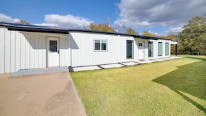 A modern single-story building with a flat roof, large windows, and a well-maintained lawn. - The HQ’ Lake Fork Home w/ Shared Dock! (Emory)