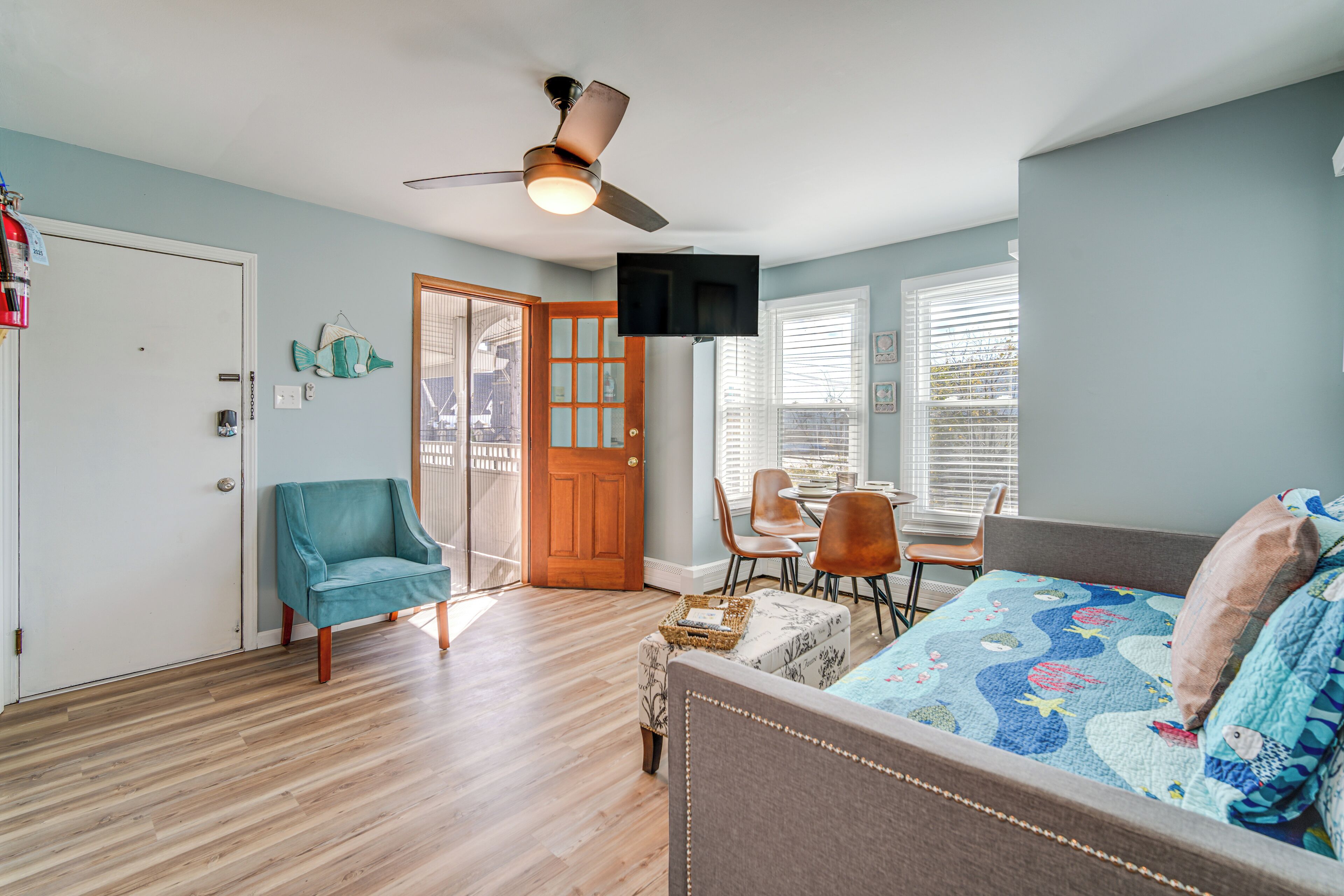 A room with a bed, a desk, a chair, and a ceiling fan.
