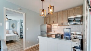 A modern kitchen with wooden cabinets, a stainless steel refrigerator, a built-in oven, and a coffee maker. - Walk to Beach & Boardwalk: Ocean City Haven! (Ocean City)