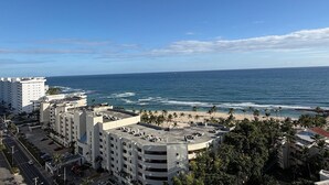 A coastal cityscape with a view of the ocean, palm trees, and modern buildings. - Hemingway By YellowKey (Guayacanes)