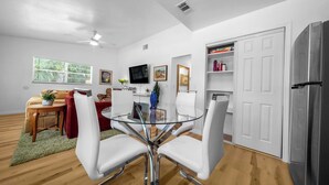 A modern kitchen with white cabinetry, a glass dining table, and a built-in refrigerator. - The Happy Haven Near Manatee Tours (Crystal River)