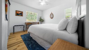 A bedroom with a bed, a desk, a chair, a window, and a ceiling fan. - The Happy Haven Near Manatee Tours (Crystal River)