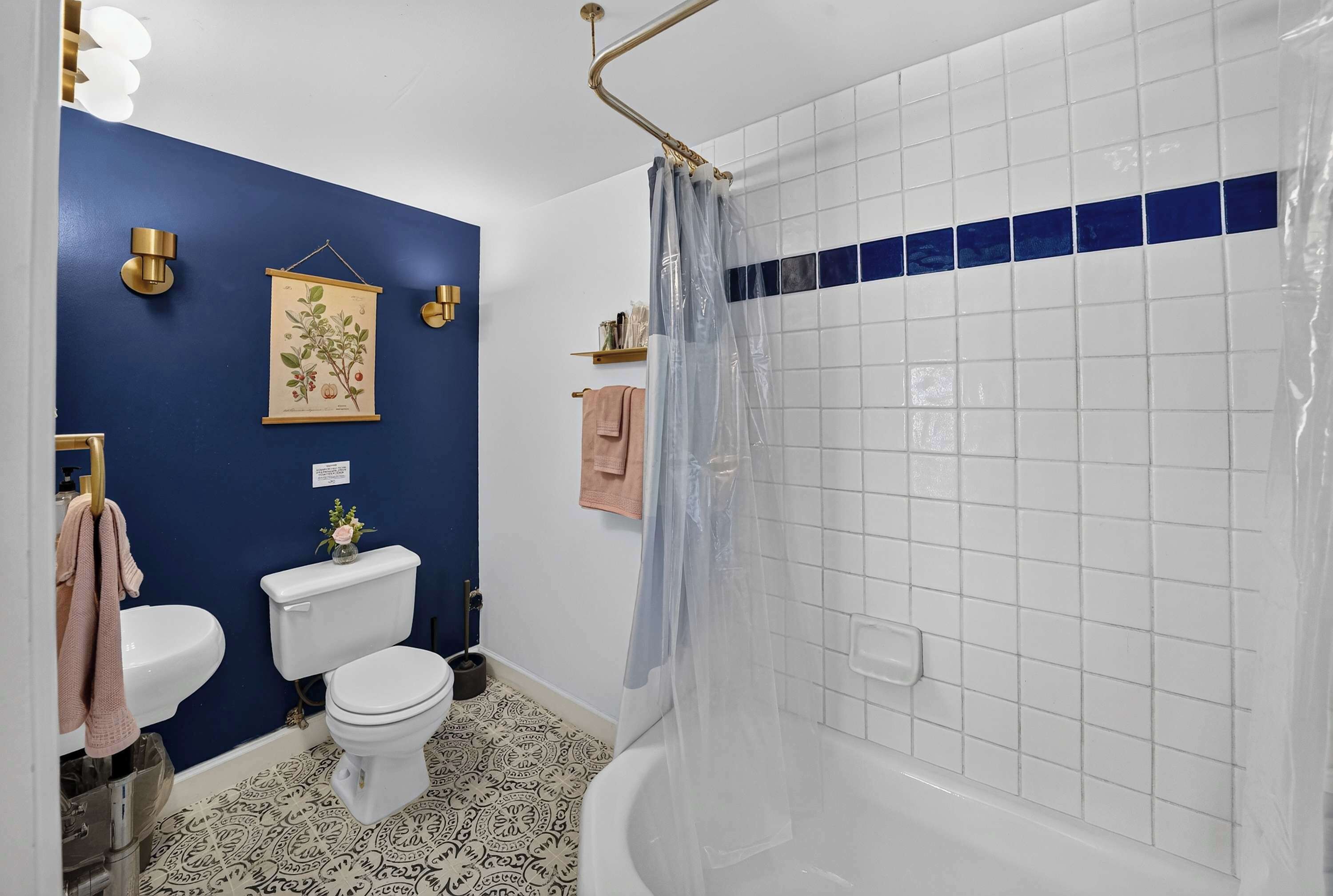 Et badeværelse med toilet, vask og badekar.