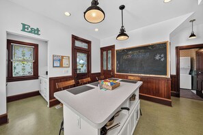 A kitchen with a chalkboard, wooden cabinets, and a chalkboard with writing. - Historic South Bend Home: Art, Comfort & Charm (South Bend)