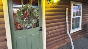 A wooden cabin with a green door, a wreath, and a window with a white frame. - Charming 1 BR Cabin at Persimmon & Pine Hollow- Secluded Feel, Close to Town (Dublin)