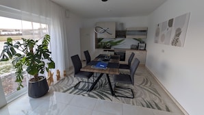 A modern dining area with a large table, chairs, and a potted plant. - Quiet apartment in the green Kreischa near Dresden (Kreischa)