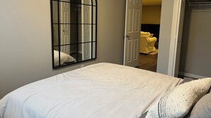A bedroom with a bed, a large mirror, and a closet. - Modern 1BD Suite•5 star Comfort•Beaumont•Edmonton (Beaumont)