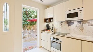 Una cocina moderna con horno empotrado, microondas y una isla grande con lavamanos.