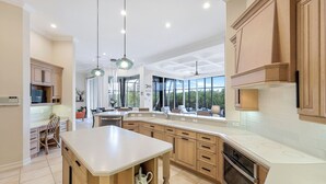 Een moderne keuken met een groot kookeiland, houten kastjes en een inbouwoven.