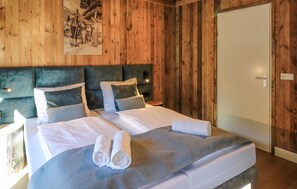 A wooden-paneled room with a bed, pillows, and a nightstand. - 3 bedroom lovely home in Afritz am See (Afritz am See)