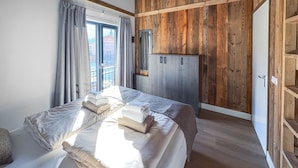 Une chambre à coucher avec un lit, une armoire et une fenêtre avec des rideaux.