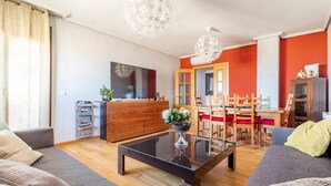 Un salon moderne comprenant un canapé, une table basse et un coin repas avec des chaises et une table.