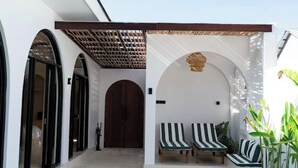 Un espace piscine avec deux chaises longues et une porte en bois.