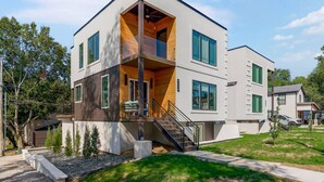 A modern two-story house with a balcony, a staircase, and a small garden area. - Private Ultra Modern Mansion - Country Club Plaza (Kansas City)