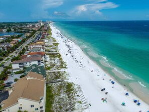 A coastal hotel with a beachfront view, a road adjacent to the beach, and a clear sky. - Semi-Private Beach Access, Heated Pool & Spa, Bikes (Destin)