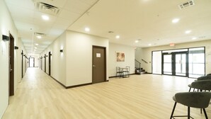 Un hall spacieux doté d’un plancher en bois, d’une porte et d’un escalier menant à l’étage supérieur.