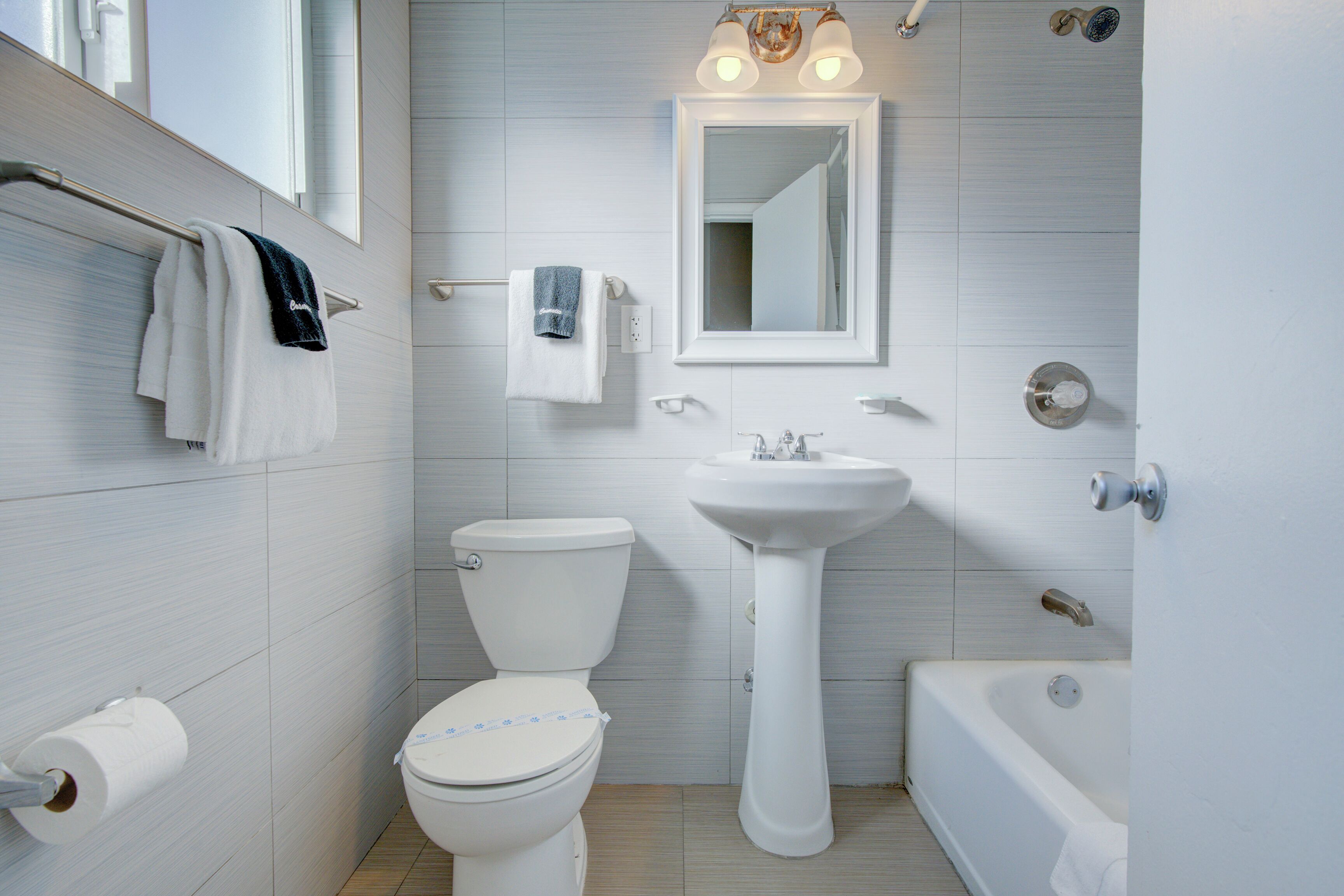 A modern bathroom with a toilet, sink, and bathtub.