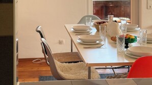 Ein Esstisch, gedeckt mit Tellern, Schüsseln, Gläsern und einem Croissant.