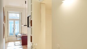 A modern interior with a wooden floor, a dining area with a table and chairs, and a kitchen area with a counter and cabinets. - VIVA - VIVA Quinta Modernista Flat (Porto)