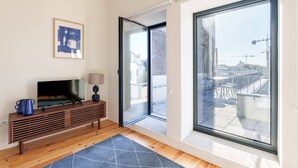 A modern living room with a flat-screen TV, a coffee table, and a sofa. - VIVA Cedofeita Serviced Apartments 11 (Porto)