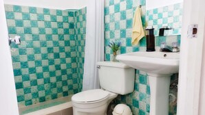 Une salle de bain comprenant des toilettes, un lavabo et un espace douche.