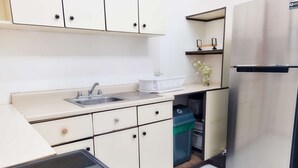A compact kitchen with a sink, a refrigerator, and a small countertop. - 714 Studios (San José)