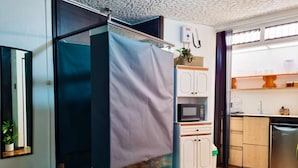 Une cuisine compacte équipée d’un four à micro-ondes, de placards et d’un lave-vaisselle.