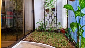 Een kleine tuin met potplanten en een decoratieve metalen hek.