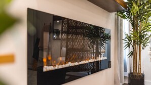 Een moderne woonkamer met een grote spiegel, een rieten mand en een hoge plant.