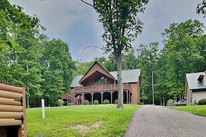 A lodge with a central wooden building, a covered porch, and a gravel driveway.