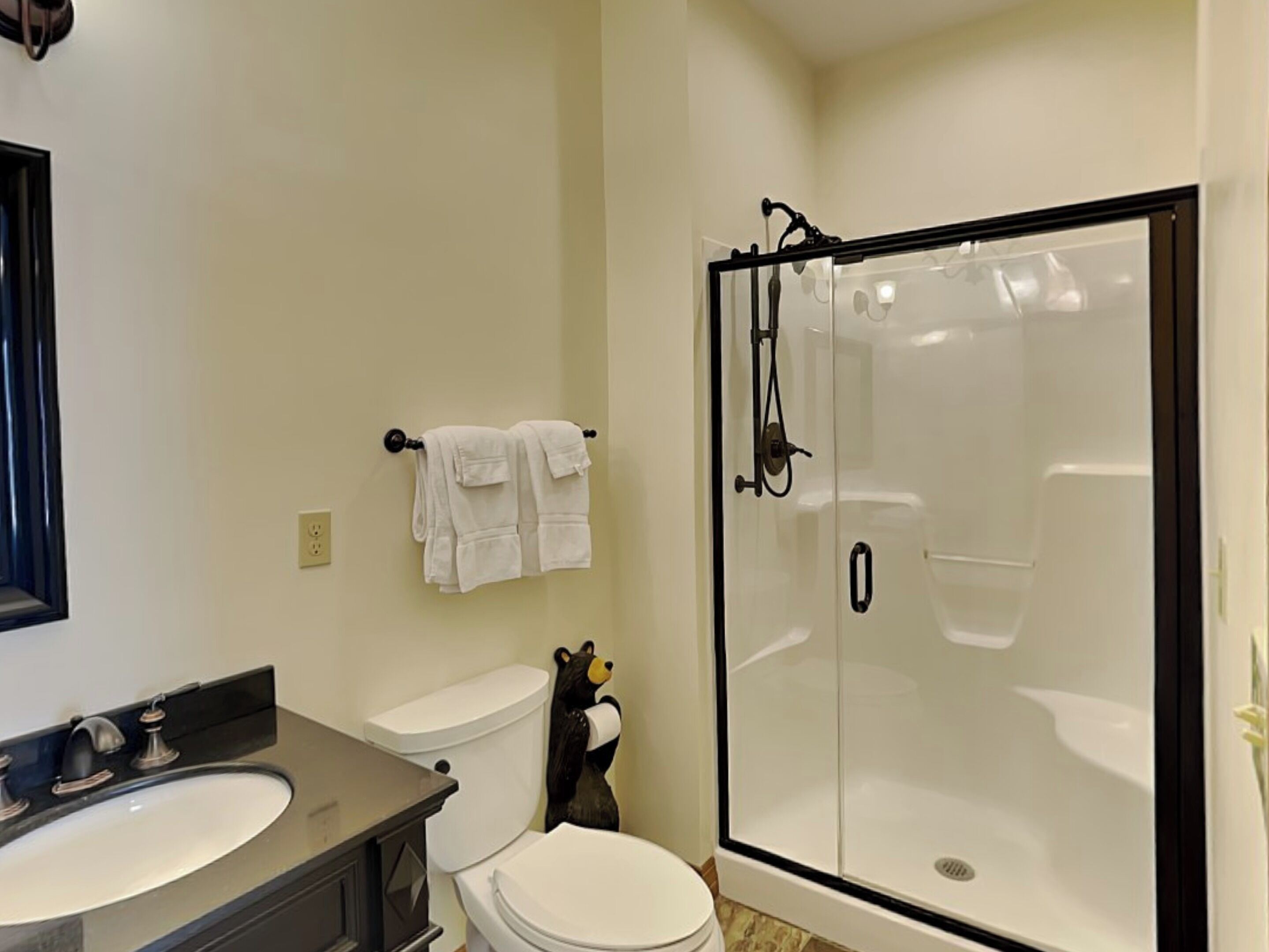 A bathroom with a toilet, sink, and a glass-enclosed shower.