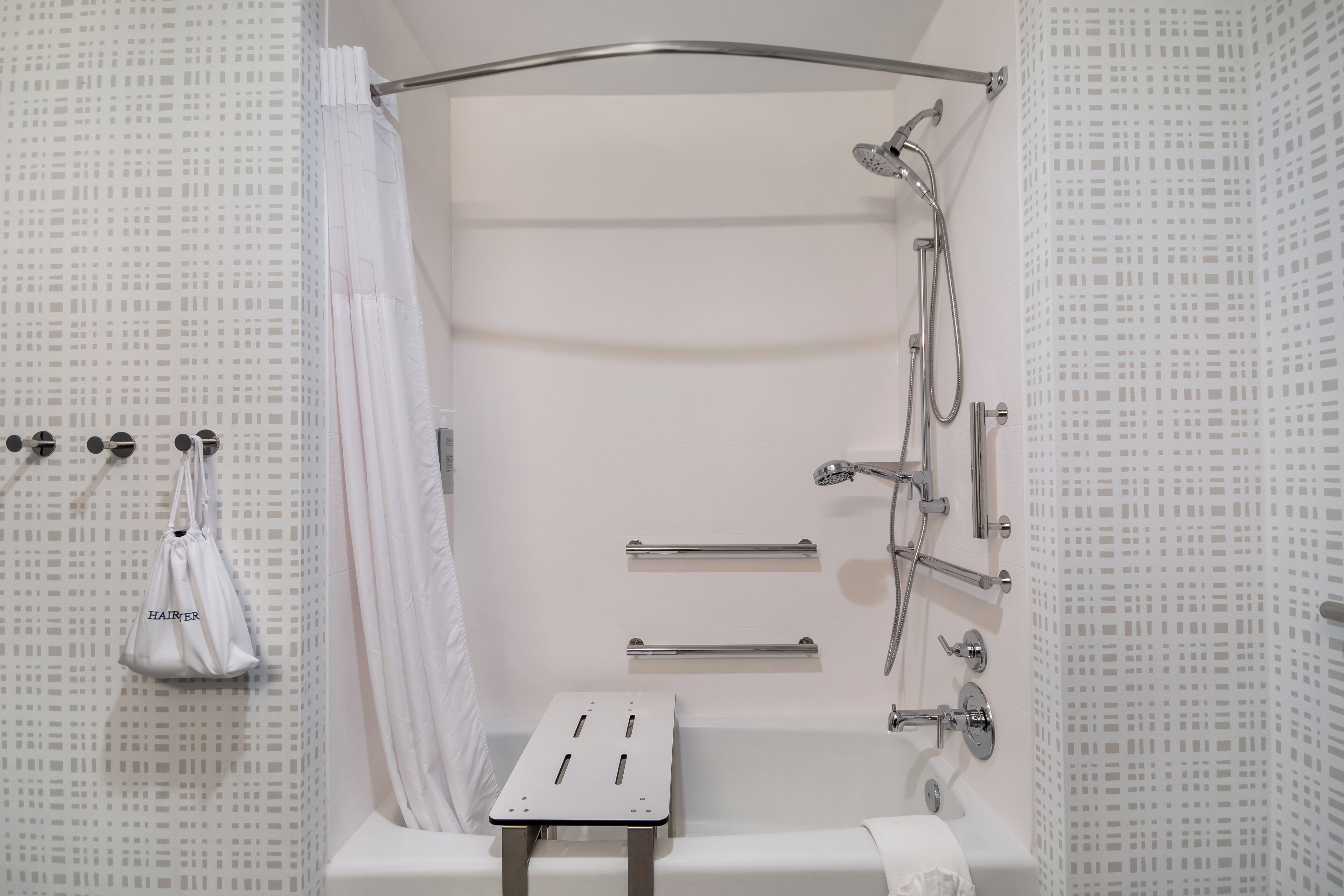 Ein modernes Badezimmer mit Dusche, Toilette und Handtuchhalter.