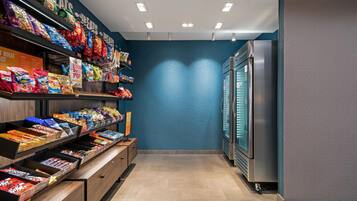 Una sección de comida para llevar con diversos productos envaselados y un refrigerador.