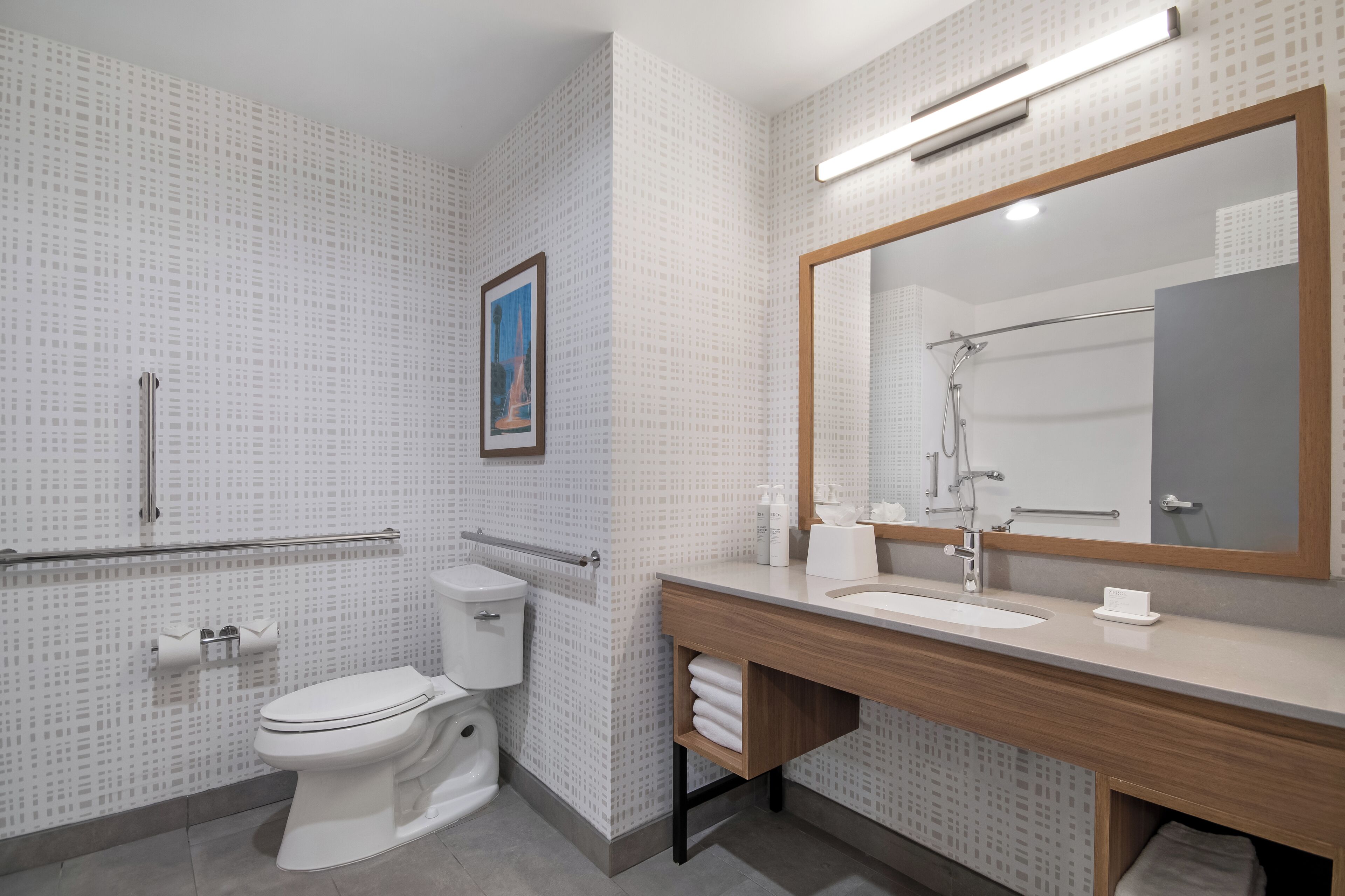 Un baño moderno con inodoro, lavamanos y ducha.